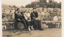 Climbers seated beside a stone wall in the club archive